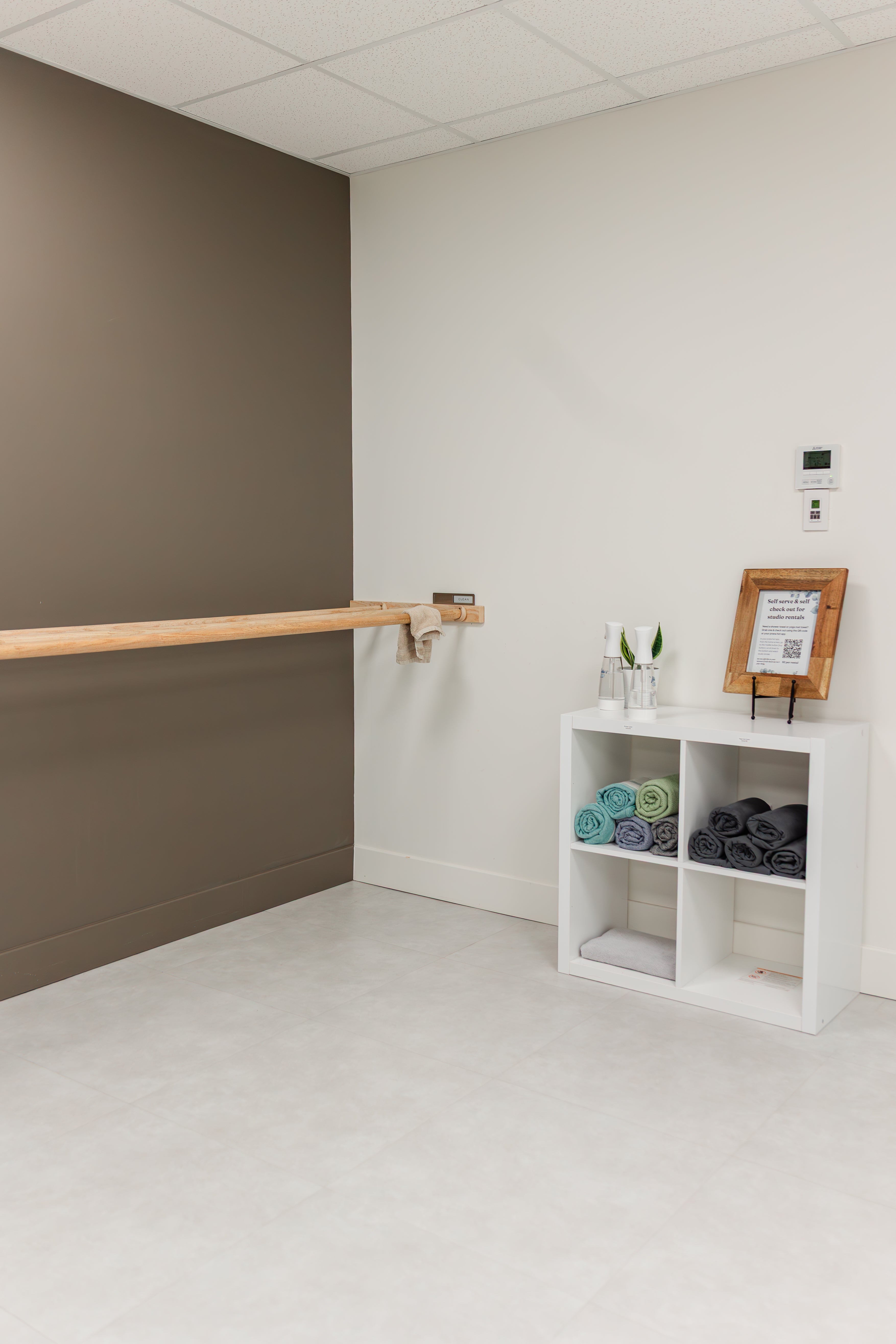 Towel station with spray bottles and a wooden barre in the Prana Fredericton changing area