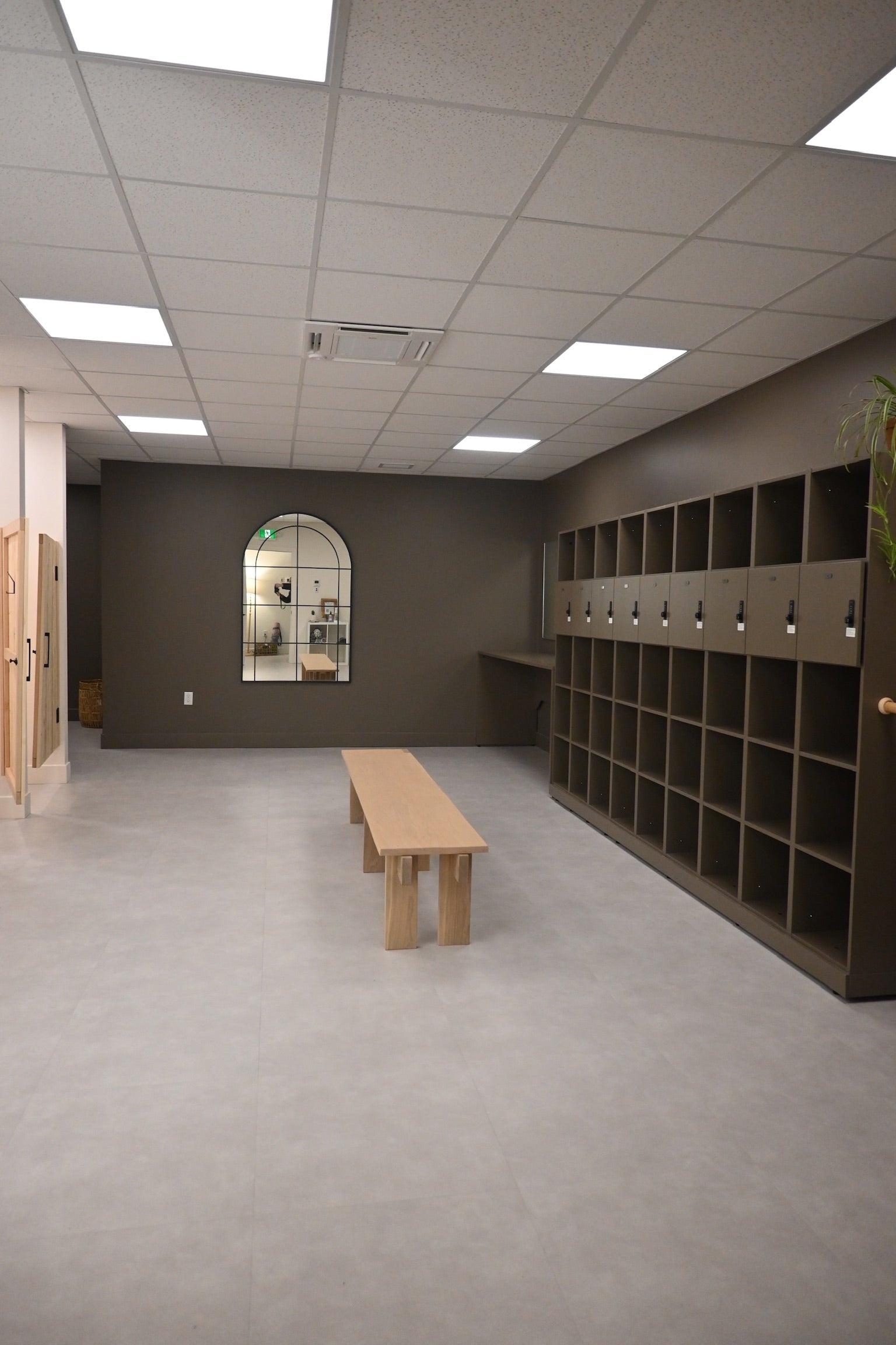 Prana Hot Yoga's spacious changing room featuring secure storage cubicles, bench seating, and private changing areas with easy access to studio facilities in Fredericton