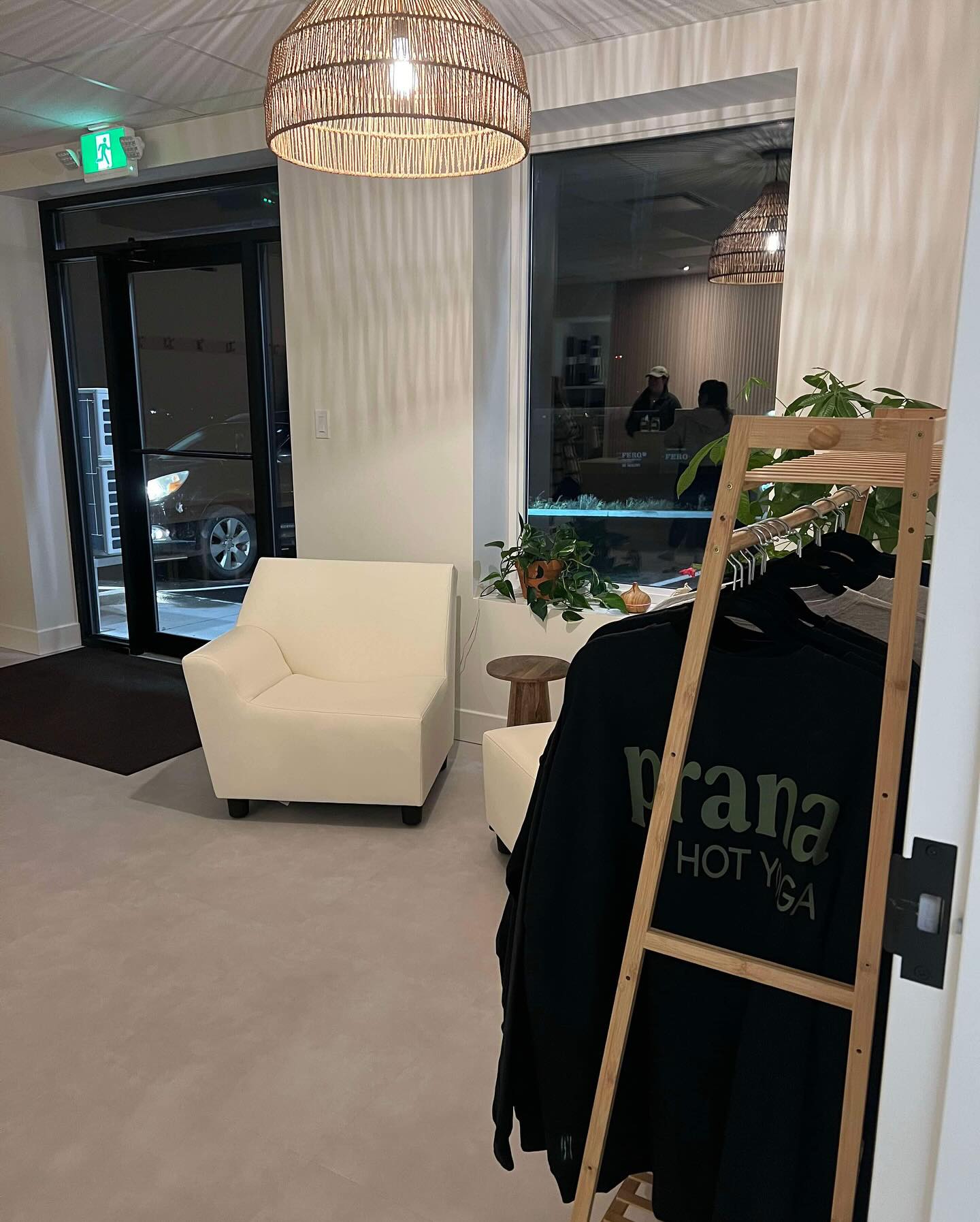 Lobby at Prana Fredericton with lounge chair, plants, and merchandise rack by the entrance