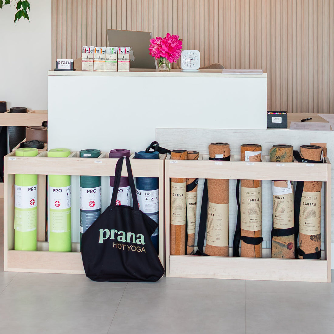 Prana Hot Yoga reception and boutique area showcasing yoga mat rentals, retail products, and welcoming community space with convenient amenities for members in Fredericton