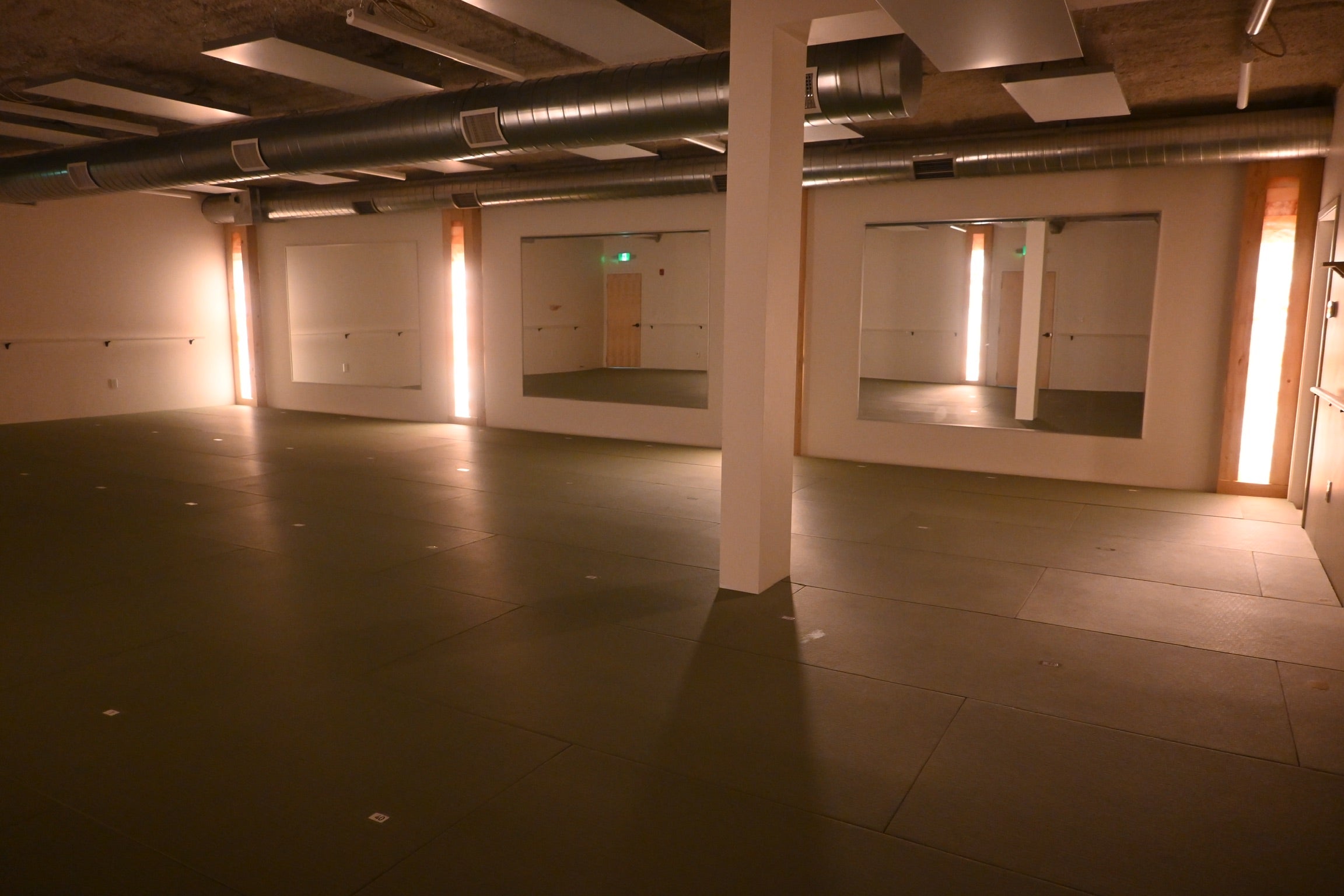 Empty Sun Room at Prana Hot Yoga showing spacious heated studio with glowing Himalayan salt columns, large mirrors, and infrared heating panels ready for hot yoga classes