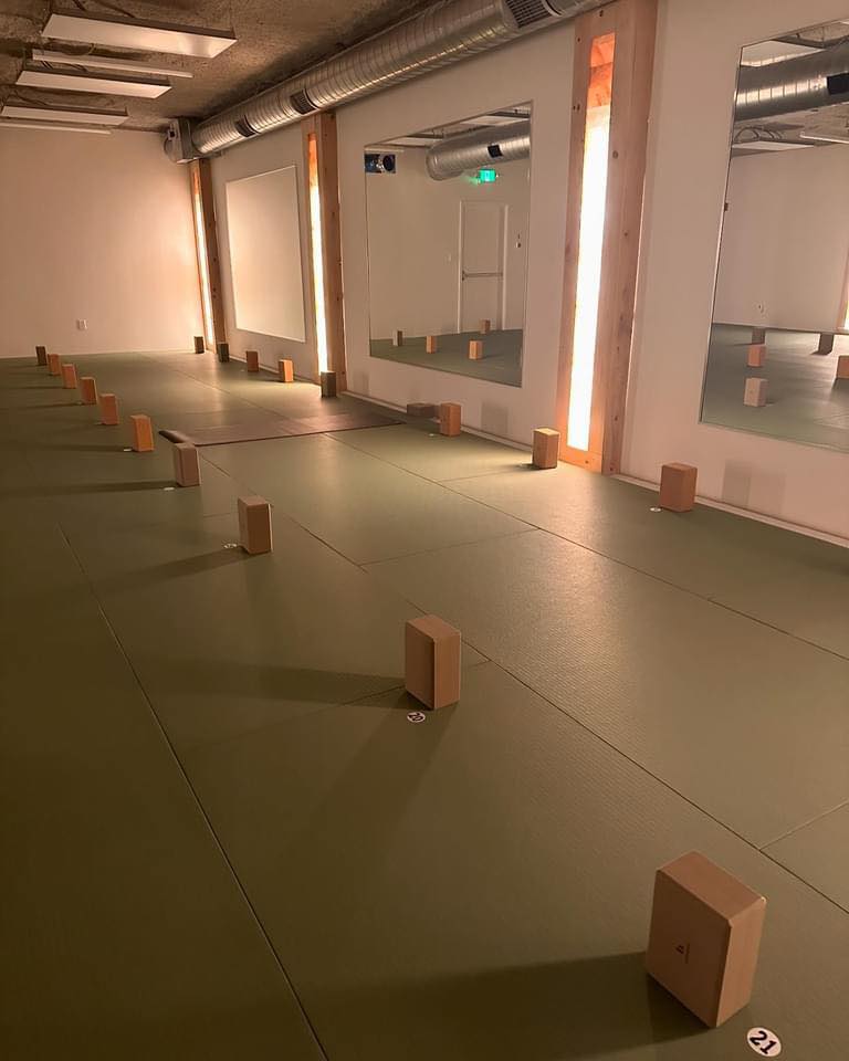 Prana Hot Yoga's Sun Room featuring 1,220 square feet of heated studio space with Himalayan salt columns, infrared panels, mirrors, and yoga blocks ready for hot yoga classes